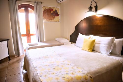 a bedroom with a large bed with a wooden headboard at Tenondé Park Hotel in São Miguel das Missões
