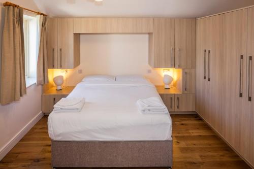 a bedroom with a large white bed with two lamps at Baggotrath House Apartments, Newbridge Ave, Dublin 4 in Dublin