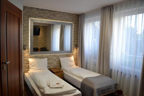 um quarto de hotel com duas camas e um espelho em Villa Vip em Gniezno
