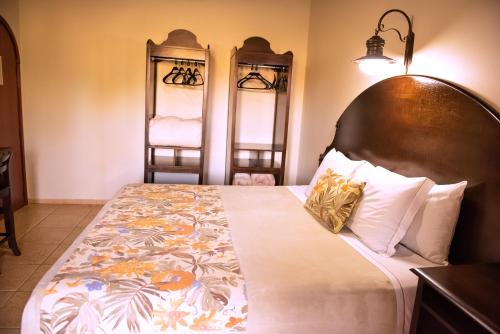 a bedroom with a large bed with a wooden headboard at Tenondé Park Hotel in São Miguel das Missões