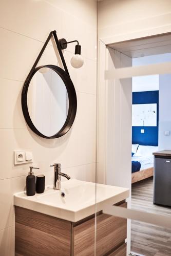 a bathroom with a sink and a mirror at Apartamenty Nad Rzeką in Polanica-Zdrój