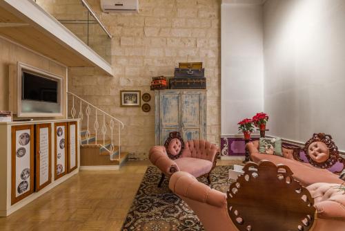 a living room with two couches and a tv at Valletta Lucente Guest House in Valletta
