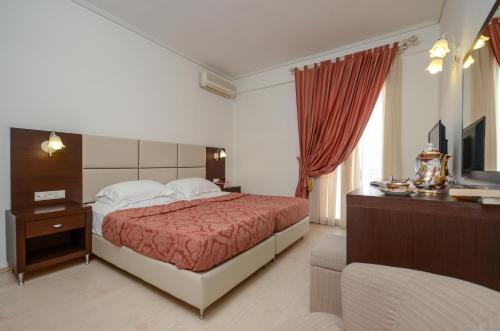 a hotel room with a bed and a television at Aeolis Boutique Hotel in Naxos Chora