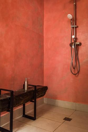 a room with a red wall with a bench and a light at Valletta Lucente Guest House in Valletta