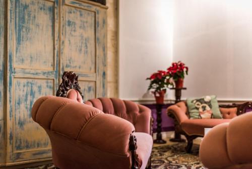 a living room with a couch and two chairs at Valletta Lucente Guest House in Valletta