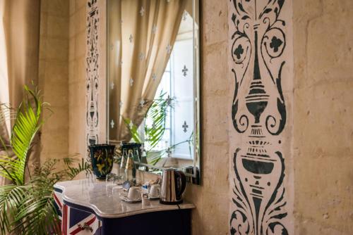 a bathroom with a mirror and a sink at Valletta Lucente Guest House in Valletta