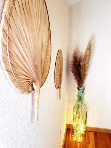 a vase with feathers on a table next to a wall at Champétillant in Épernay