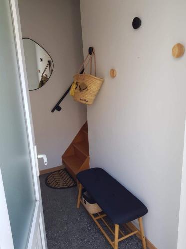 a room with a blue chair and a mirror at Champétillant in Épernay