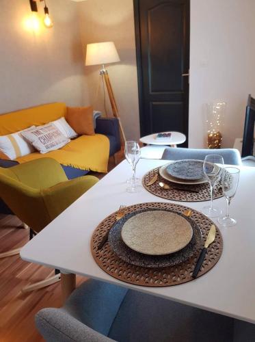 a table with two plates and wine glasses on it at Champétillant in Épernay