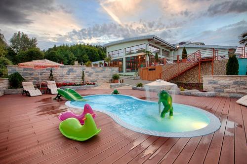 a pool on a deck with a house at Wellness & Spa Hotel Kaskady in Sliač