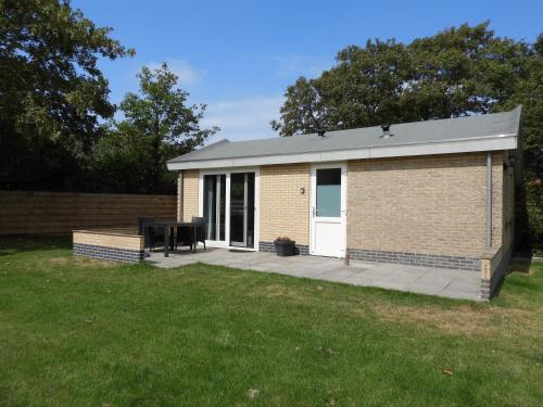 a brick building with a picnic table in a yard at Vakantiewoning 't Steechje in Hollum