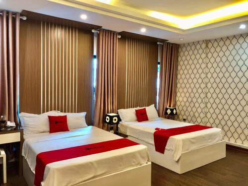 a bedroom with two beds with red and white sheets at The Royal Hotel Near West Lake in Hanoi
