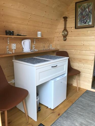 a bathroom with a white sink and two chairs at Ásahraun Guesthouse in Selfoss