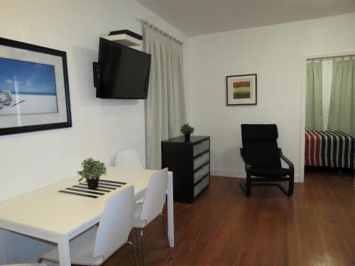 a living room with a white table and a black chair at Harding Boutique Apartments in Miami Beach