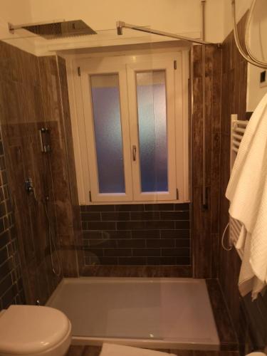 a bathroom with a tub and a toilet and a window at Brutia Mom&Son in Cosenza