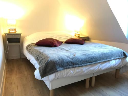 um quarto com uma cama com duas almofadas em Le Studio du Gouverneur em Honfleur