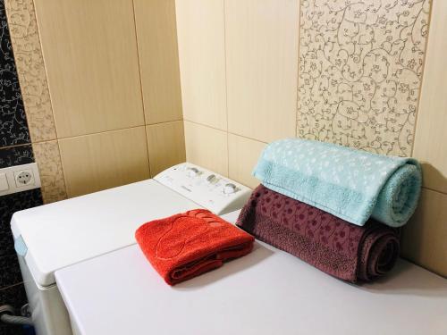 リウネにあるApartment Rovnoのバスルームのトイレの上に座ったタオル2枚