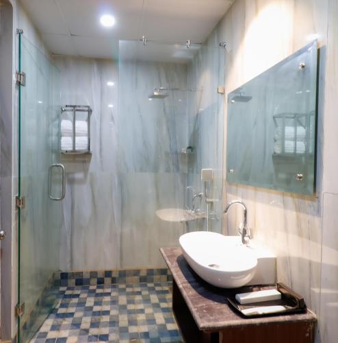 a bathroom with a sink and a shower at Miranda Beach Resort Baga in Baga