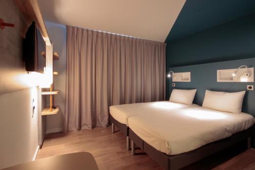Cette chambre comprend 2 lits et une fenêtre. dans l'établissement ibis budget Cahors, à Cahors