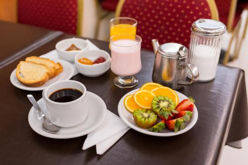 a table with a plate of fruit and a cup of coffee at Estocolmo Hotel by bund in Mar del Plata