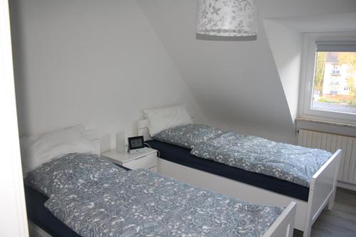 two beds in a small room with a window at Fewo Kerstin in Oberhausen
