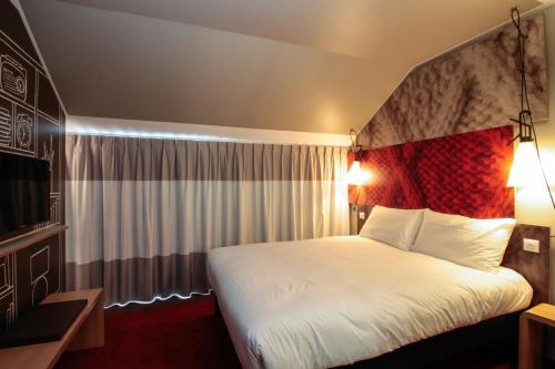 a hotel room with a bed and a television at ibis Cahors in Cahors