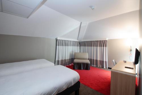 a hotel room with a bed and a desk at ibis Cahors in Cahors