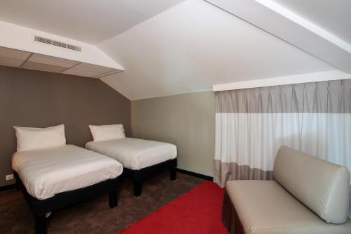 a room with two beds and a couch at ibis Cahors in Cahors