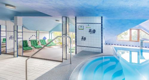 ein Badezimmer mit einem Pool in der Unterkunft Sport- und Tagungshotel De Poort in Goch