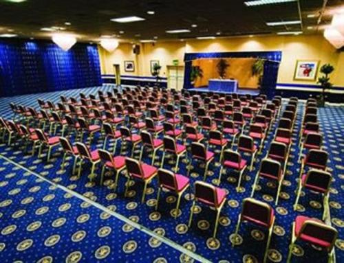 a large room with chairs and a stage in a room at Carrington House Hotel in Bournemouth