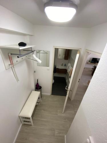 a white room with a bench and a bedroom at Apartment Hannover /Laatzen in Hannover
