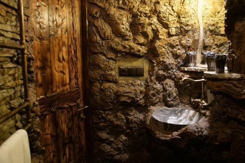a stone bathroom with a sink in a stone wall at Boutique Fantasy in Tbilisi City