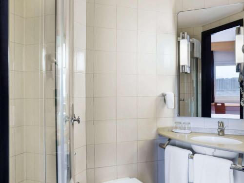 a bathroom with a sink and a toilet and a mirror at ibis Muscat in Muscat