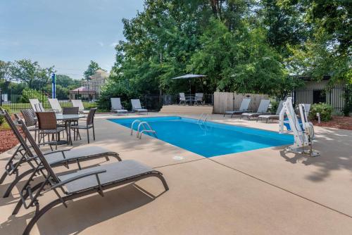 a swimming pool with chairs and a table and a swimming pool at Comfort Inn Indianapolis South in Indianapolis