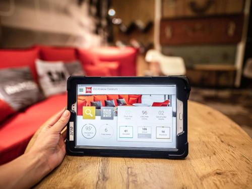 a person holding a tablet computer on a table at Hotel Ibis Krakow Centrum in Kraków