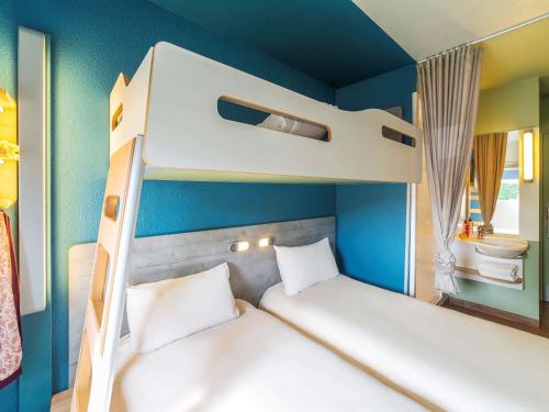 two bunk beds in a room with blue walls at Ibis budget Rouen Petit Quevilly in Le Petit-Quevilly