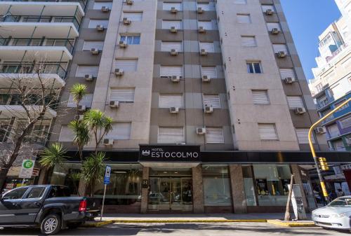 a large apartment building with a truck parked in front of it at Estocolmo Hotel by bund in Mar del Plata