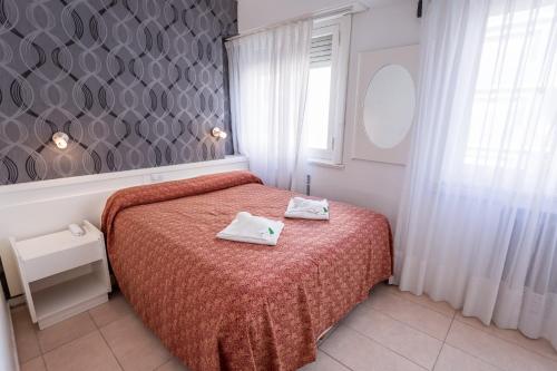 a bedroom with a bed with two towels on it at Estocolmo Hotel by bund in Mar del Plata