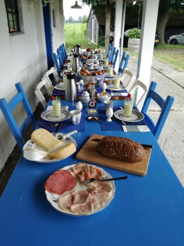 a long blue table with plates of food on it at Wijnstaete in Lemelerveld