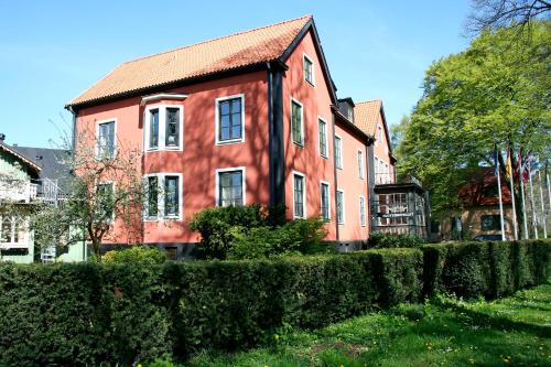 a red house with a fence in front of it at Slottshotellet in Kalmar
