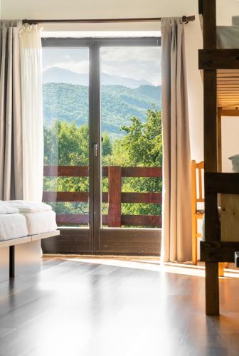 a room with a large glass door with a view at Pensiunea ANA Vistisoara in Vistisoara