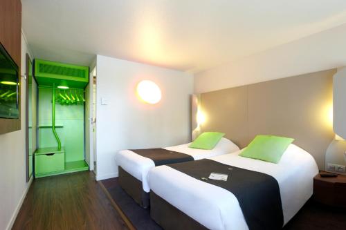- 2 lits dans une chambre d'hôtel avec des touches de vert dans l'établissement Campanile Montargis - Amilly, à Amilly