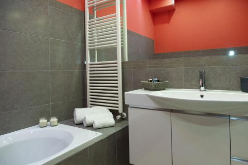 a bathroom with a white sink and a tub at Casa e Mare in Montignano