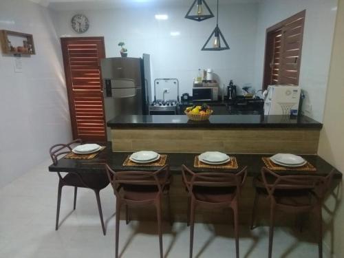 a kitchen with a table and chairs and a counter at Maragogi Chalé Antunes in Maragogi