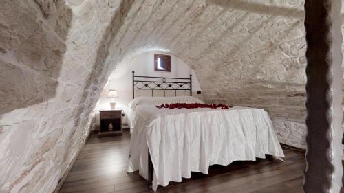 a bedroom with a bed in a stone wall at Il Trullo dei Sogni in Alberobello