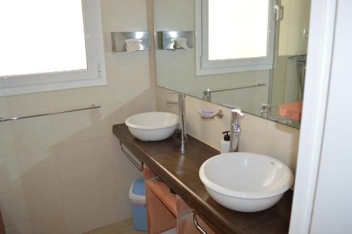 a bathroom with two sinks and a mirror at Villa Transatlantique en première ligne de mer dite Villa Esmeralda in Llafranc