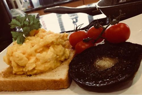 a plate of food with eggs and bread and tomatoes at The Moorhead Bed & Breakfast in Wem