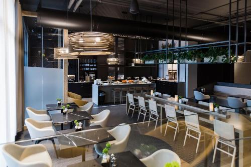 un restaurante con mesas y sillas y un bar en Alt Hotel Saskatoon, en Saskatoon