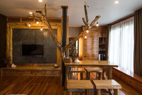 a living room with a wooden table and a tv at Andalay Beach Resort Koh Libong in Ko Libong