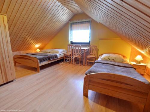 a attic room with two beds and a window at Pokoje Gościnne Dorota Andreasik in Wetlina
